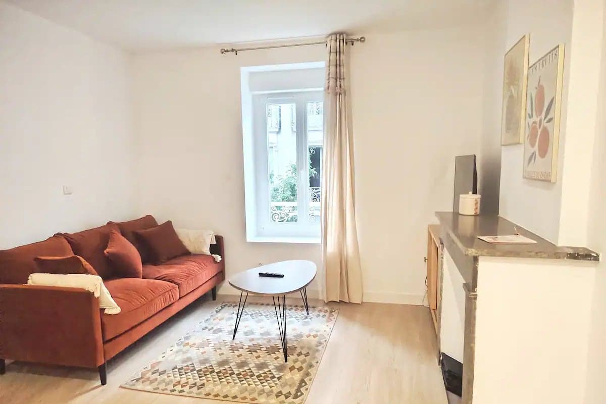 Salon lumineux avec canapé en velours d'un appartement géré par Hostimo